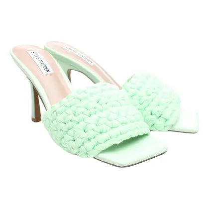 Light green woven high-heeled shoes on a white background