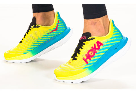 Brightly colored running shoes with a visible brand logo on a white background