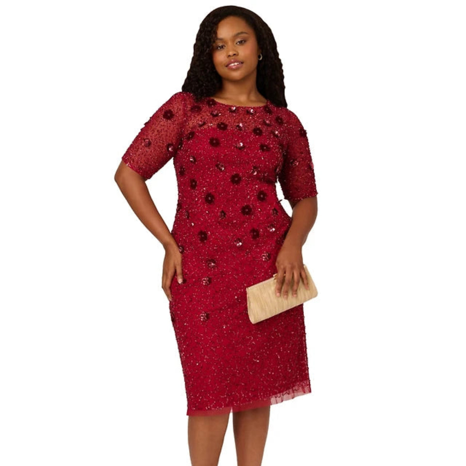 Woman wearing a red patterned dress on a white background