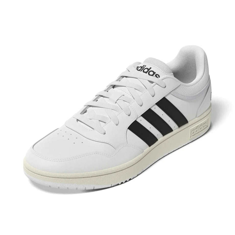 A white Adidas low-top sneaker with black three-stripes on the side, white laces, and a cream-colored midsole and outsole, shown on a clean white background.