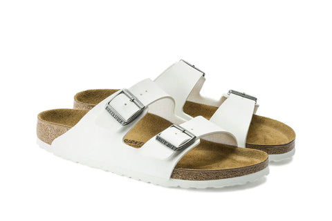 White sandals with brown soles on a white background
