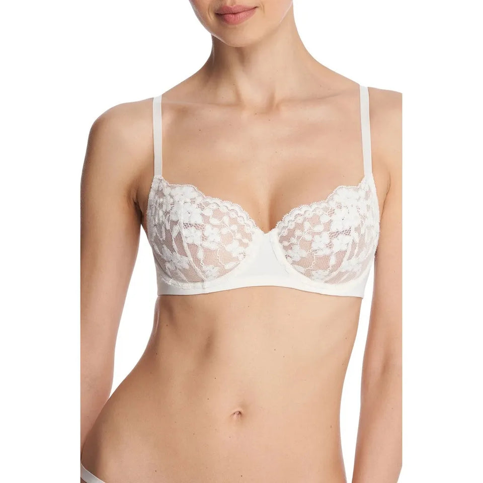A woman wearing a white underwire bra with floral lace cups and thin shoulder straps, shown from the neck to the hips against a plain white background.