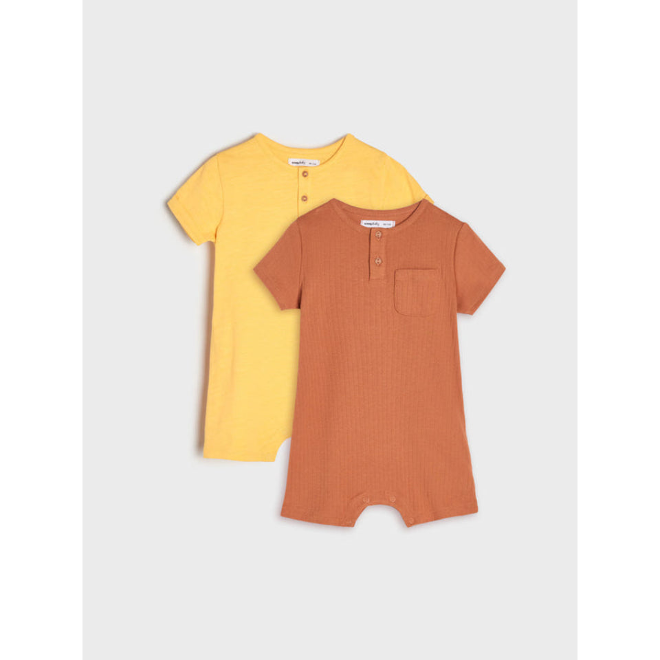 Two short-sleeve baby henley romper suits by Maja & Jaja, shown in a two-pack. One is a soft mustard yellow and the other is a warm terracotta orange, both featuring a ribbed texture, buttoned neck, and a chest pocket, displayed against a light gray background.