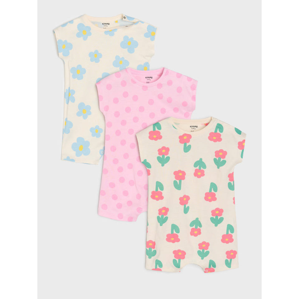 Three short-sleeve baby t-shirts in a set of three, featuring floral and polka dot patterns. The top-left shirt is cream with light blue and yellow flowers.