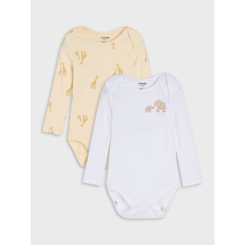 Two long-sleeve baby bodysuits from KIKKANS on a light gray background. The top bodysuit is pale yellow with a cactus and giraffe print, and the bottom bodysuit is white with a small elephant graphic on the chest.