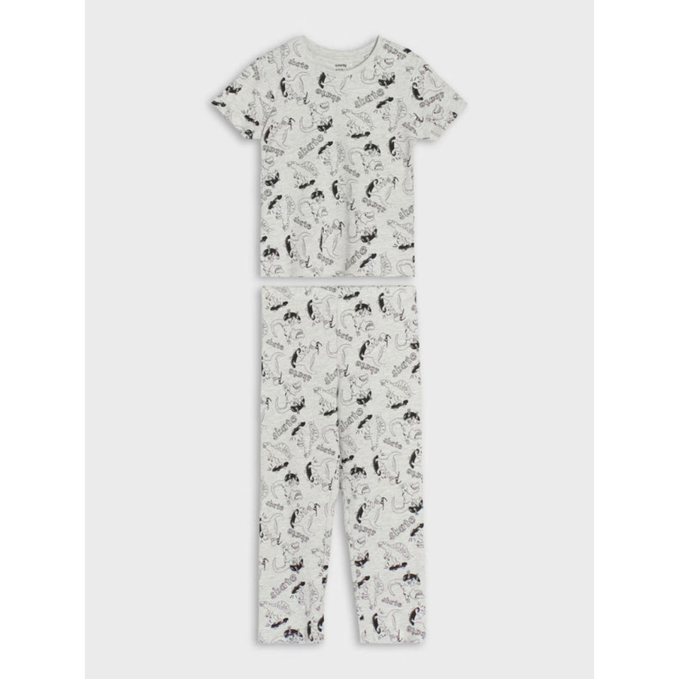 A two-piece children's pajama set featuring a short-sleeve top and matching pants, both in an off-white fabric with a black and gray dinosaur print, shown flat on a light gray background.
