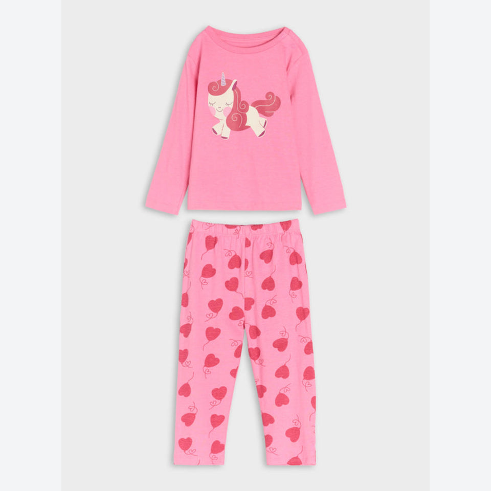A two-piece children's pajama set in pink, featuring a long-sleeve top with a cartoon unicorn graphic and matching pants with a red heart pattern, displayed on a light gray background.