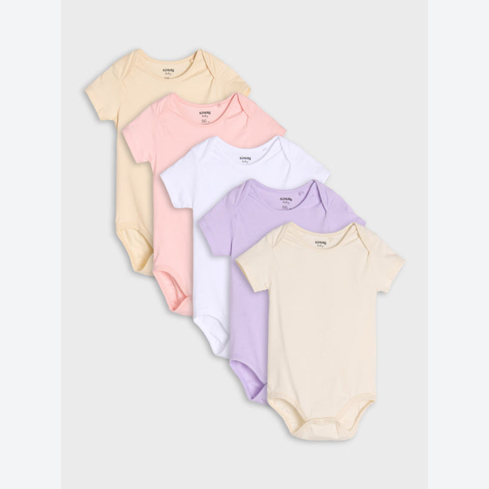 Five short-sleeve baby bodysuits in pastel colors, arranged in a fan shape on a light gray background. The colors are cream, light pink, white, lavender, and pale yellow.