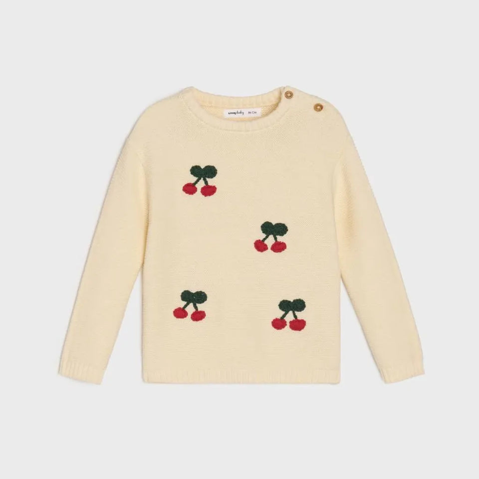 A cream-colored knit sweater for toddlers, featuring embroidered cherry motifs with red berries and dark green leaves, displayed on a light gray background.