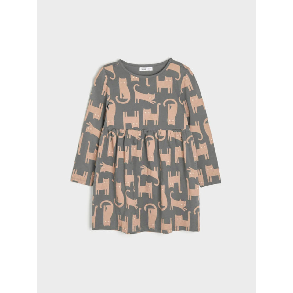 A long-sleeve children's dress with a gathered waist and an all-over cat print in dusty pink on a gray background, shown flat against a light gray backdrop.