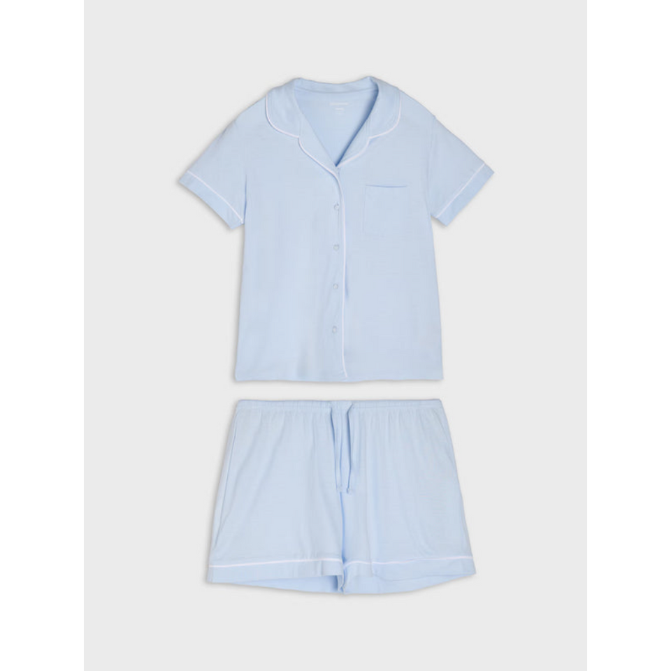 A light blue two-piece pajama set consisting of a short-sleeve button-front top with a collar and matching shorts, laid flat on a light gray background.