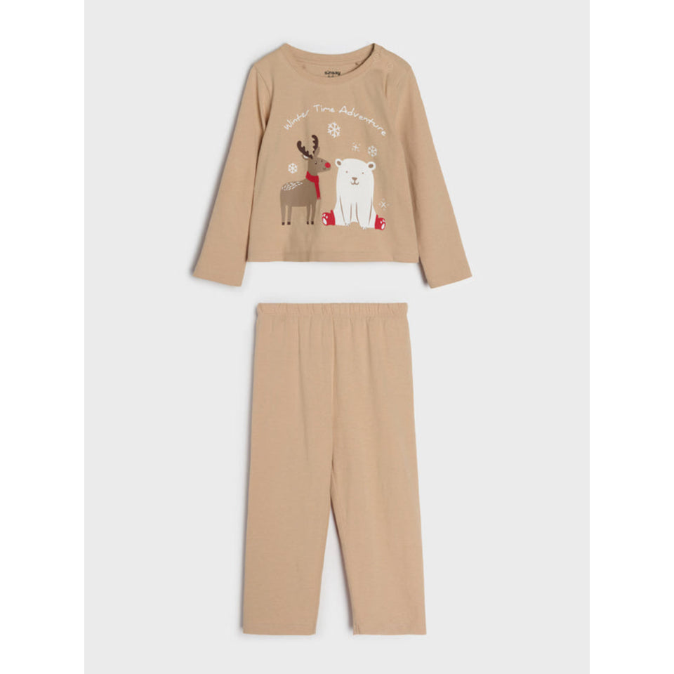 A two-piece children's pajama set in a warm beige/tan color, featuring a long-sleeve top with a festive graphic of a reindeer, polar bear, and snowflakes, paired with matching straight-leg pants, shown against a light gray background.