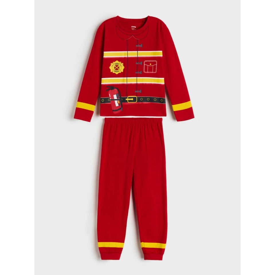 A two-piece children's pajama set featuring a red long-sleeve top and matching pants with yellow and black firefighter-themed printed details, shown on a light gray background.