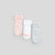 Three pairs of baby socks laid flat on a light gray background: one pink pair with white cloud patterns, one white pair with a pale pink heart, and one light gray pair.
