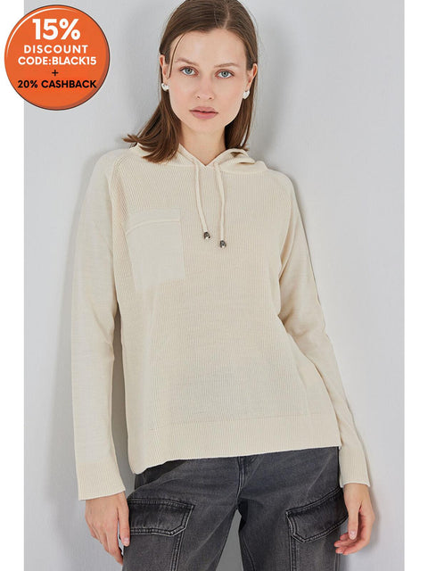 Woman wearing a beige hoodie against a plain background