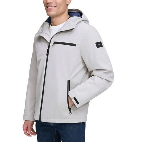 Light gray jacket with black zippers worn by a person on a white background