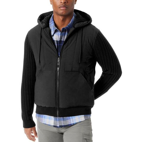 Man wearing a black zip-up hoodie over a plaid shirt on a white background
