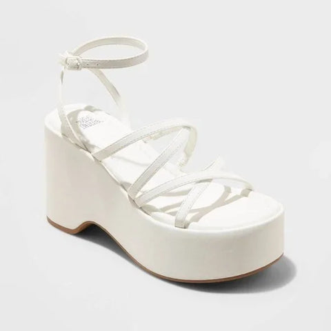 White platform sandal with strappy design on a light gray background