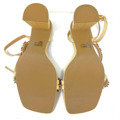 Pair of gold sandals with decorative straps on a white background