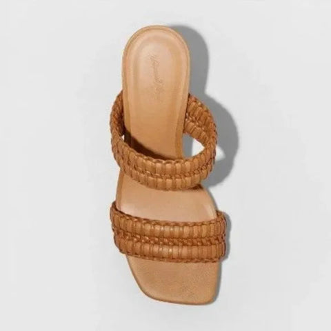 Tan woven sandal on a light gray background