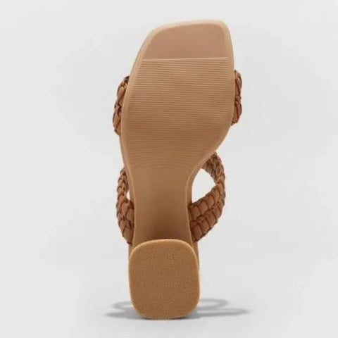 Brown sandal with braided design on a light gray background