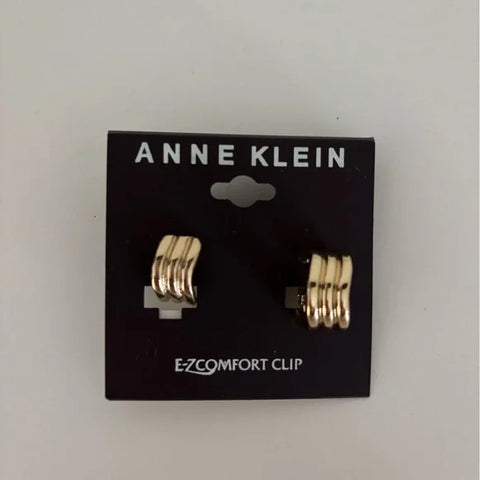 Gold earrings on Anne Klein packaging with a white background