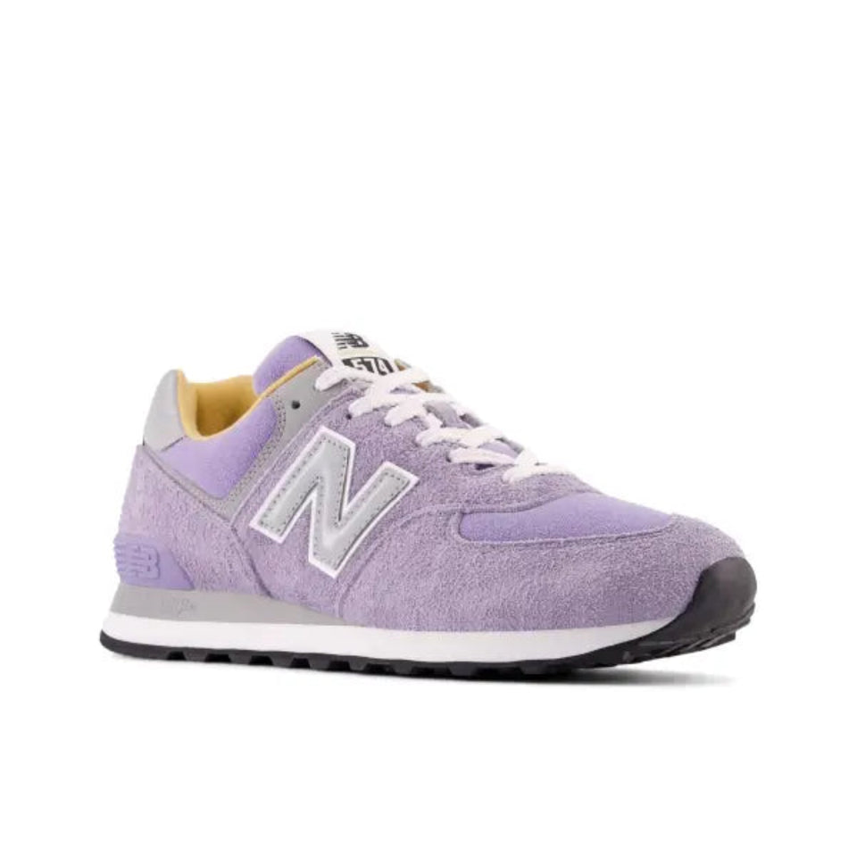 A single New Balance sneaker in lavender purple suede and mesh, featuring a light gray 'N' logo, white laces, a white midsole, and a black outsole, shown against a plain white background.