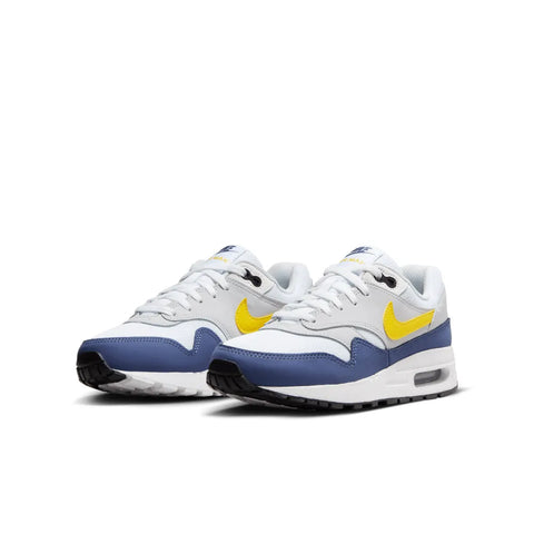 White sneakers with blue accents and yellow Nike logos on a white background