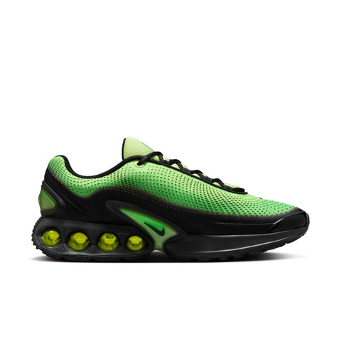 Green and black sneaker with unique sole design on a white background