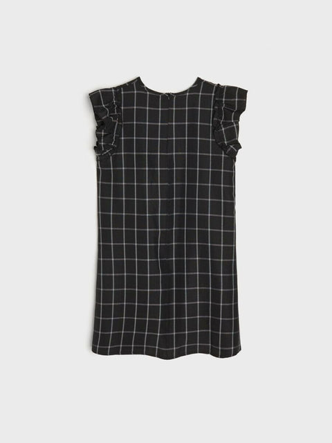 Black and white checkered dress with ruffled sleeves on a light gray background