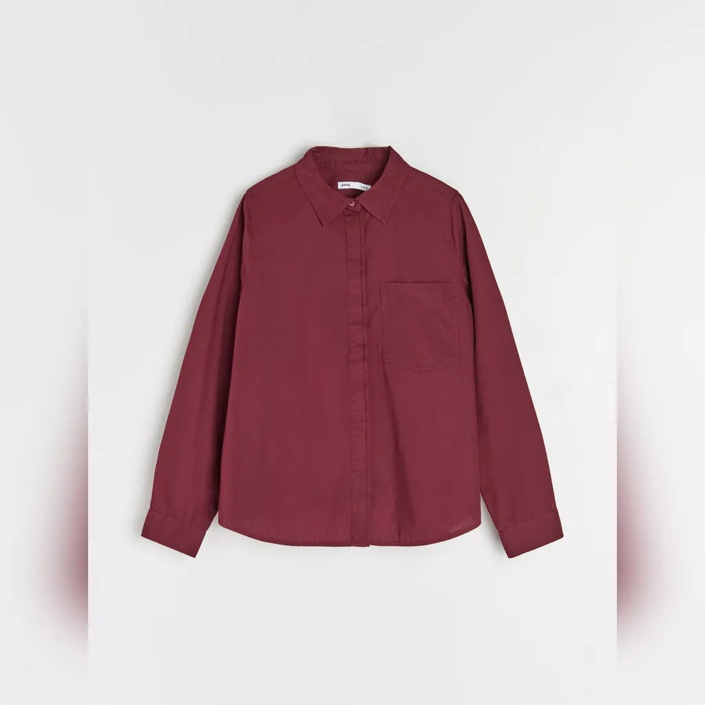 A long-sleeve button-up shirt in a deep burgundy color, featuring a classic pointed collar, a single chest pocket, and buttoned cuffs, shown against a light gray background.
