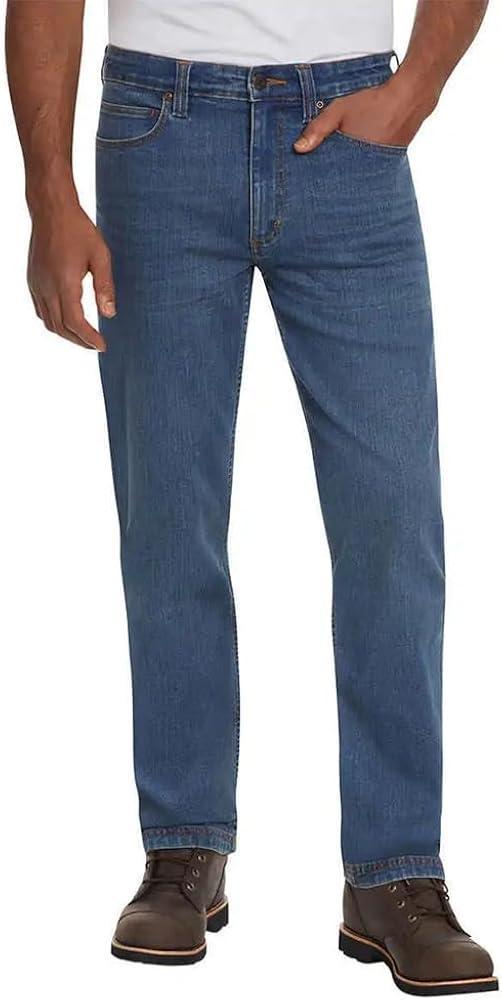 Person wearing blue jeans and brown shoes on a white background