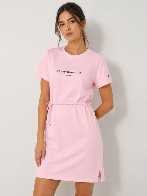 Woman wearing a pink Tommy Hilfiger dress against a white background