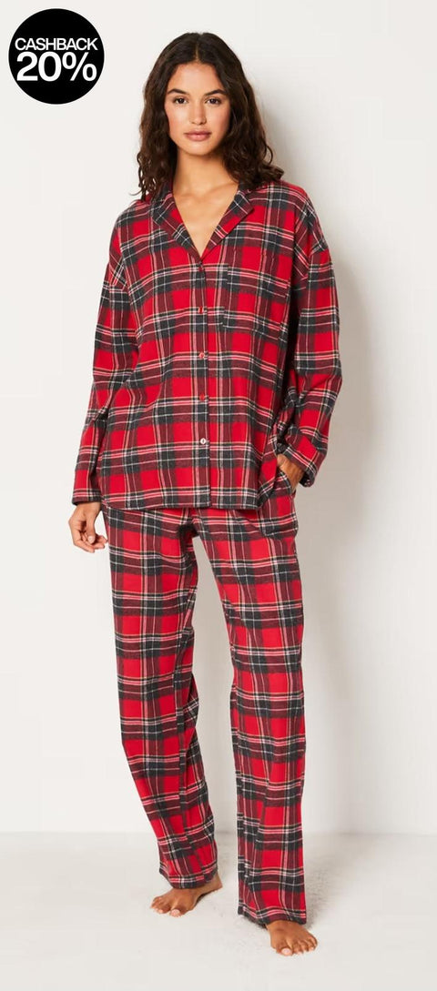 Woman wearing red and black plaid pajamas on a white background