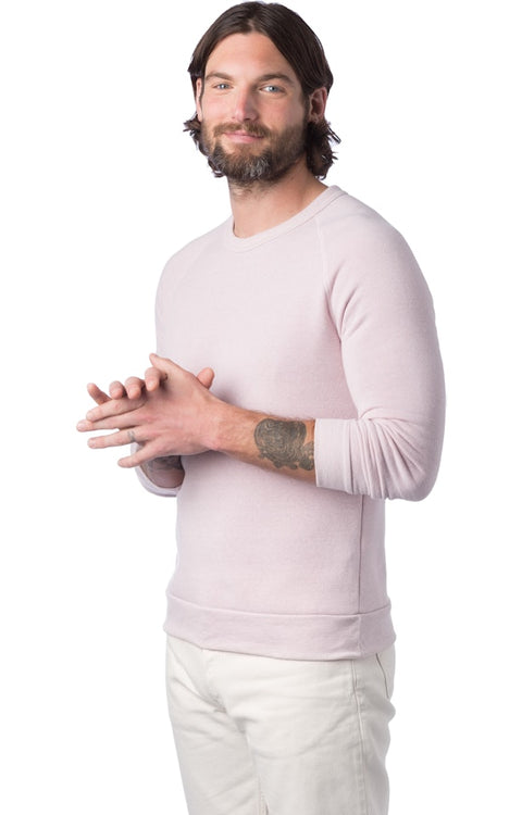 Man wearing a light pink long-sleeve shirt and white pants on a white background
