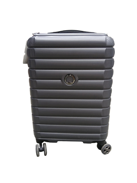 Black suitcase with wheels on a concrete floor in a warehouse setting