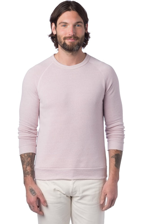 Man wearing a light pink sweater and white pants on a white background