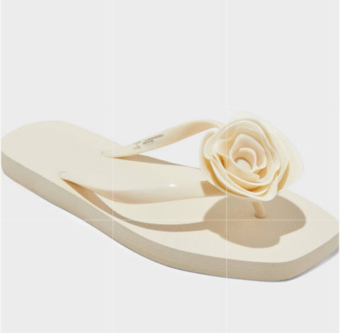 Beige flip-flop sandal with a flower decoration on a white background