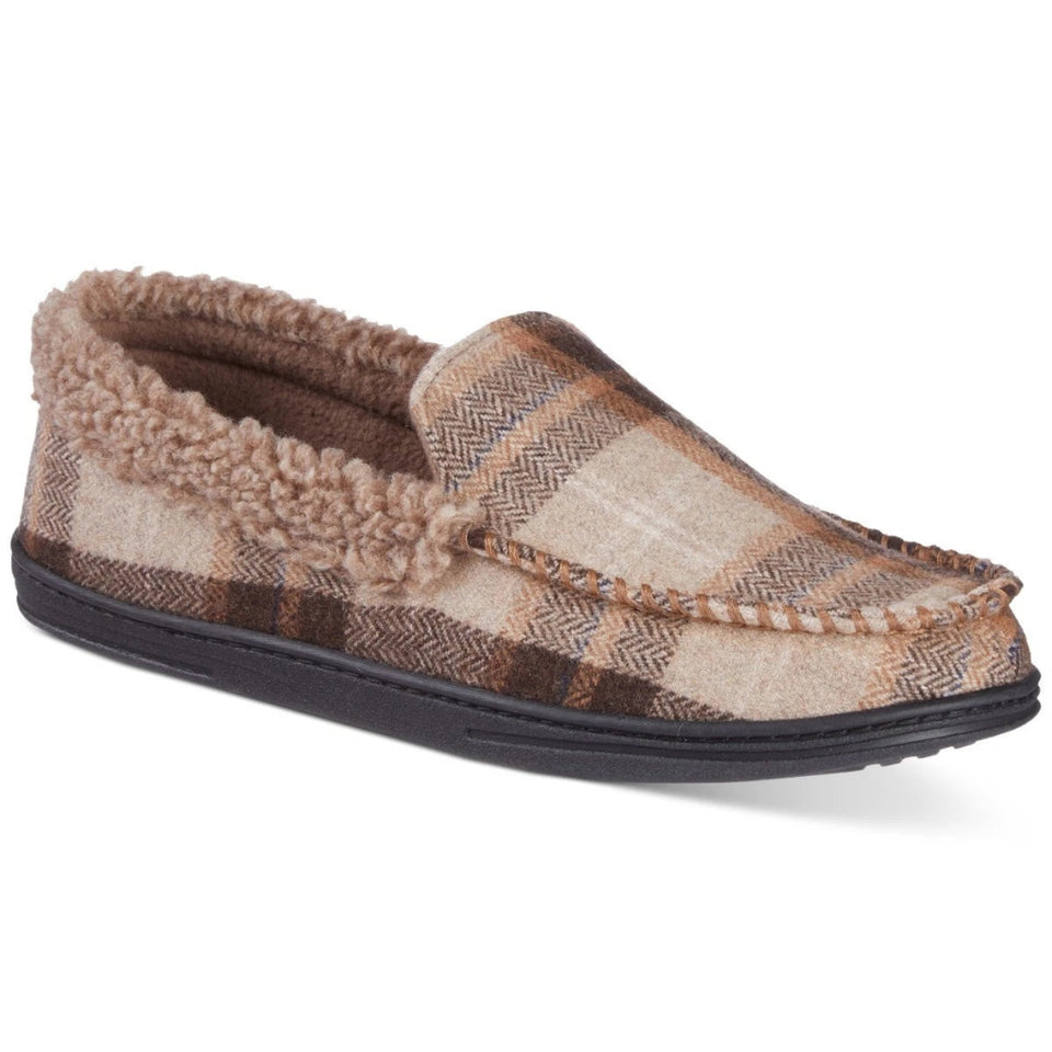 A single slip-on moccasin-style slippers featuring a brown and beige plaid pattern, a soft tan sherpa lining, and a black sole, shown against a plain white background.