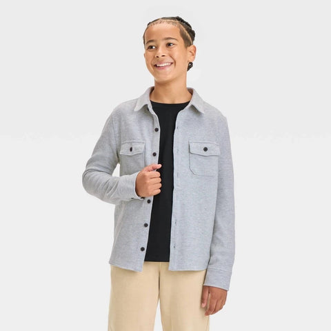 Person wearing a gray button-up shirt over a black t-shirt on a white background