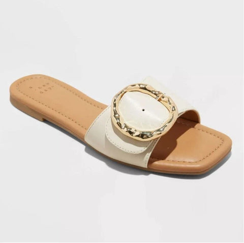 Beige sandal with a decorative strap on a light gray background