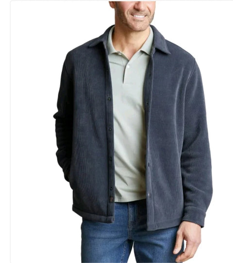 Man wearing a dark blue jacket over a light shirt and jeans on a white background