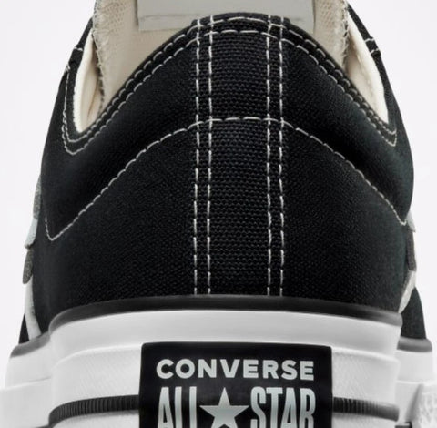 Close-up of a black Converse All Star sneaker with white stitching on a white background