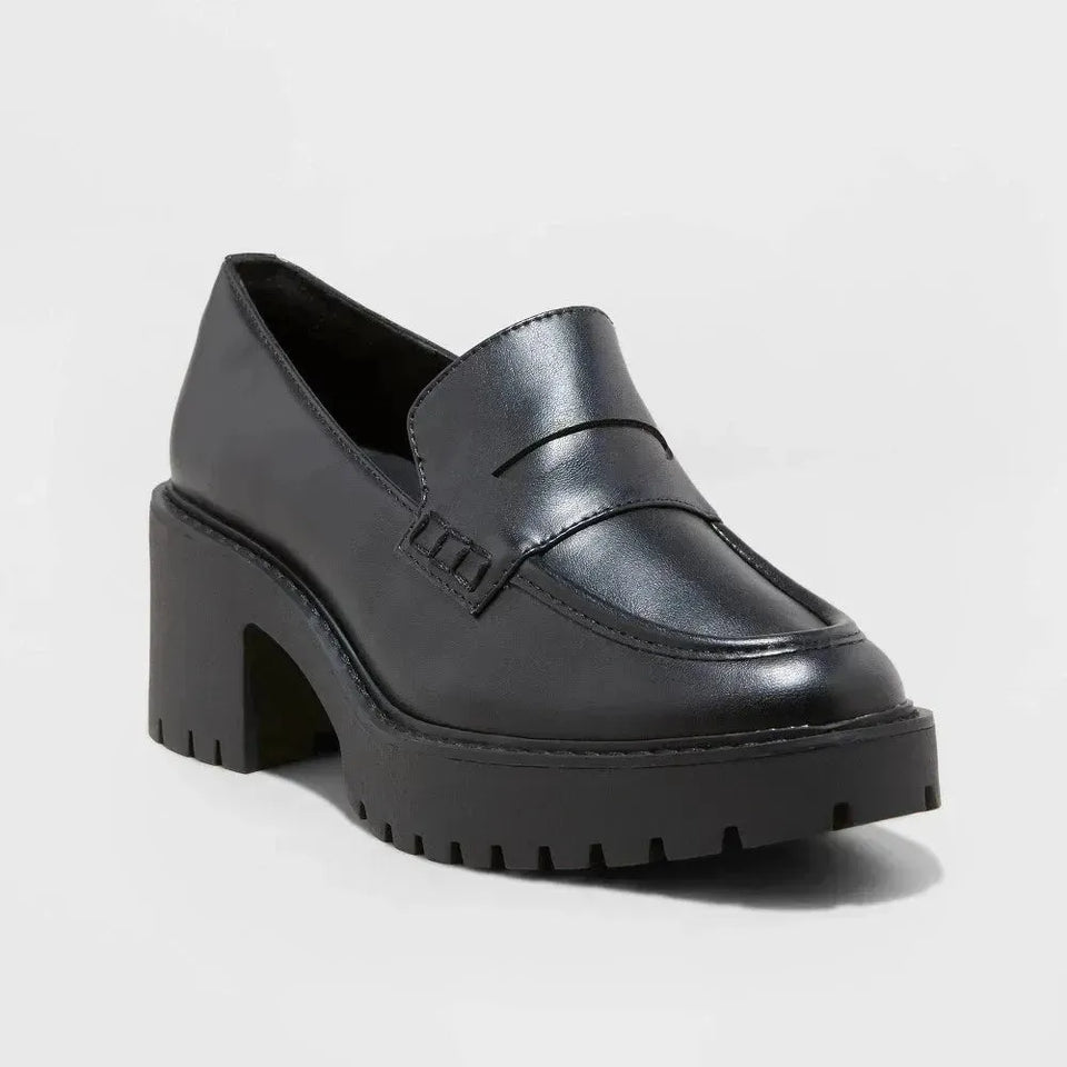 Black platform loafer shoe on a light gray background