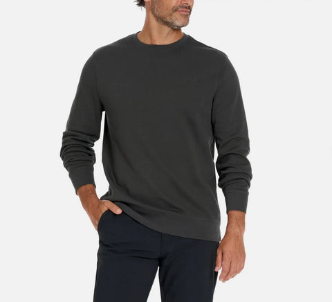 Man wearing a dark gray sweatshirt and black pants on a white background