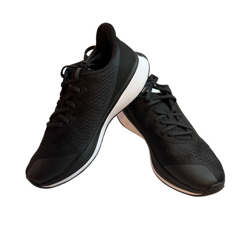 Black running shoes with white soles on a white background