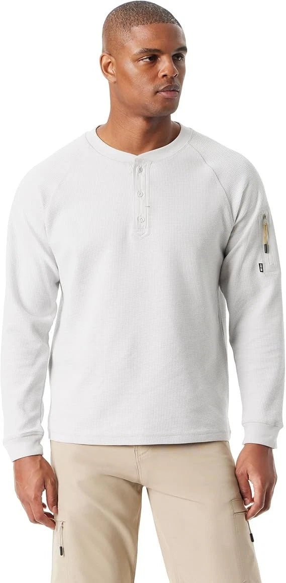 Man wearing a light gray long-sleeve shirt with a brand logo on a white background