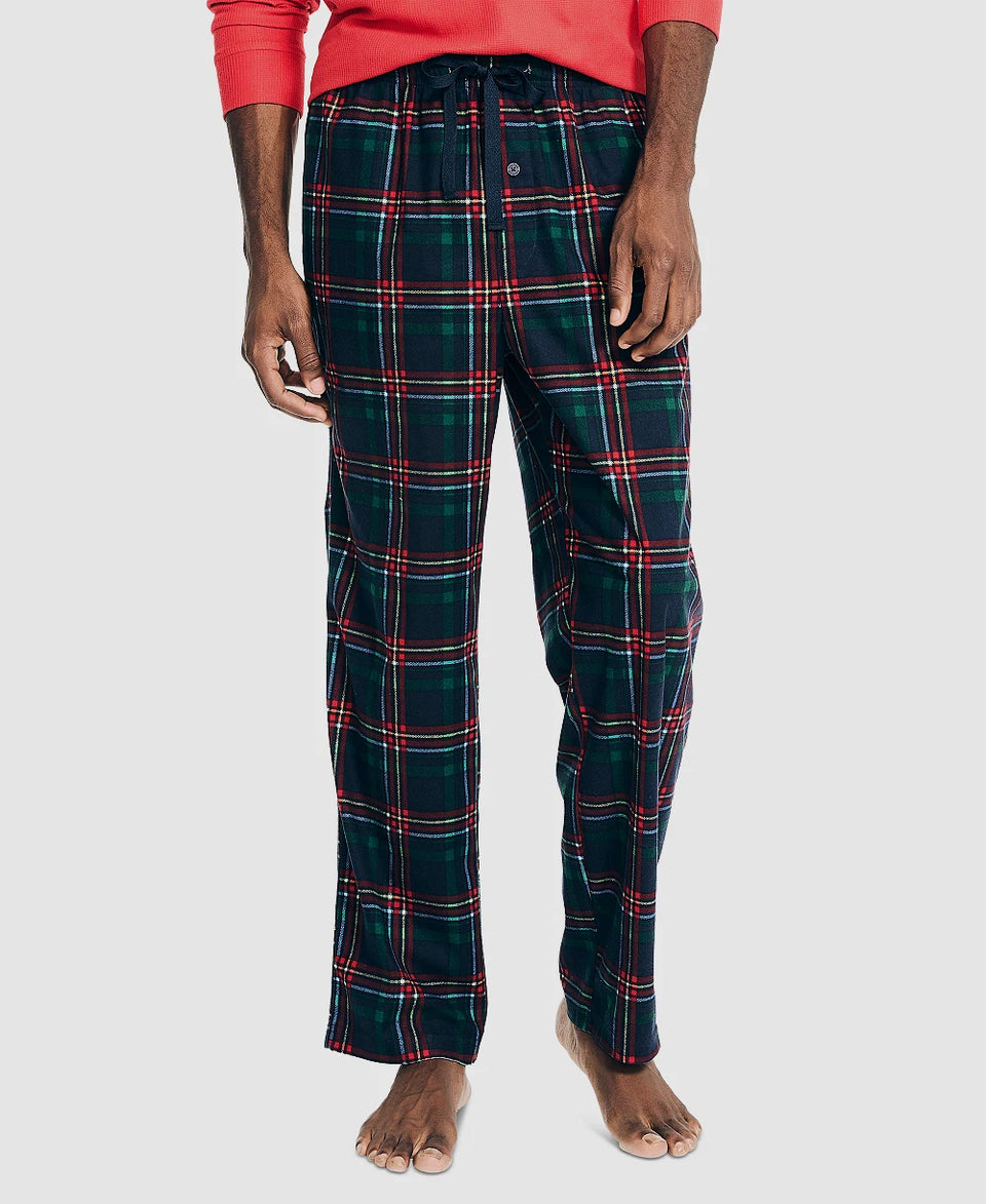 Person wearing dark green plaid pajama pants on a white background