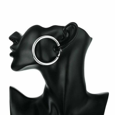Silver hoop earring on a black mannequin ear display against a white background