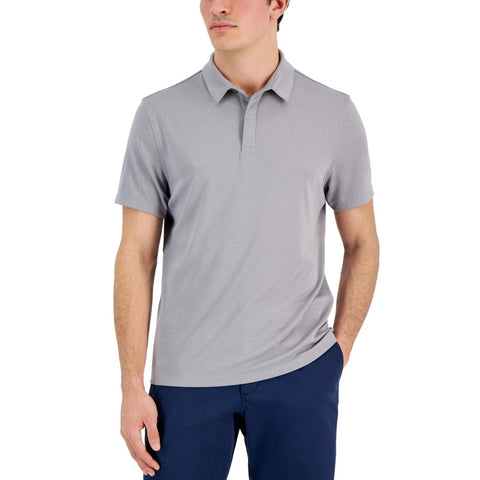 Man wearing a gray polo shirt and navy pants on a white background